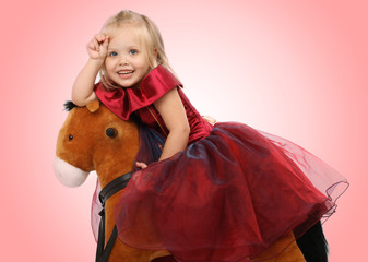 Portrait of the beautiful girl on a toy horse