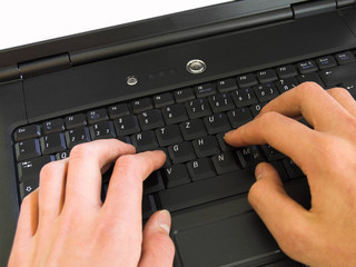 Hände tippen auf einer Laptop-Tastatur