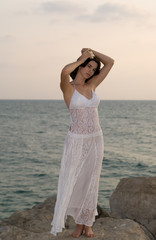 Young woman at beach staying on the rock