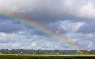 Obraz na płótnie Canvas rainbow over coastal marsh with boats