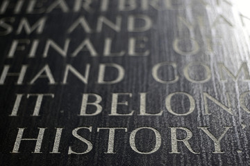 A closeup of the word HISTORY engraved on a war memorial.