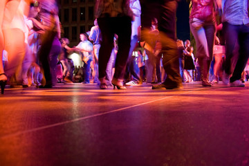 The dance floor with people dancing under the colorful lights.