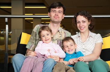 Obraz premium family sit on sofa in dark hall