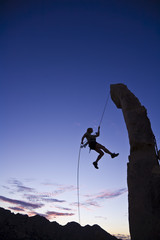 A rock climber rappelling.