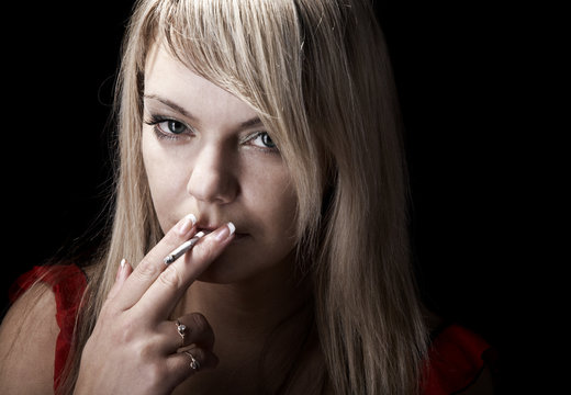 Young girl smoking on black isolated background