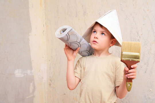 boy with brush and roll of wallpaper in papper hat