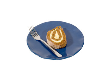 Piece of pumpkin roll on blue plate with fork