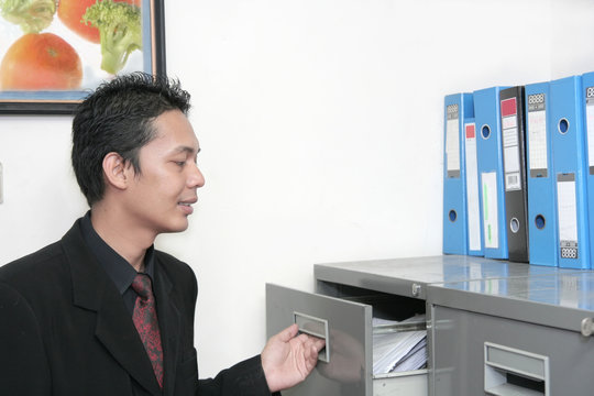 Business Man In Office Opening File Cabinet