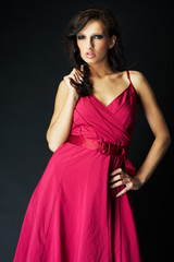 Obraz premium girl wearing a nice ping dress on black background