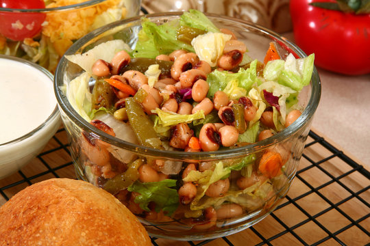 Glass bowl of black eye pea salad in kitchen or restaurant.