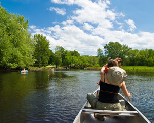 Young woman paddling on a gentle little river