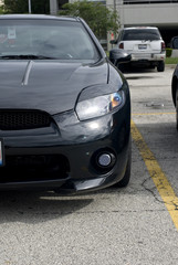 Fototapeta premium Black automobile's driver's front bumper and headlight