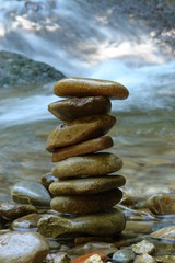 peebles in balance in front of a water fall
