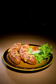sausages on plate with tomatoes..
