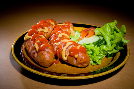 sausages on plate with tomatoes..