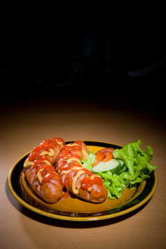 sausages on plate with tomatoes..
