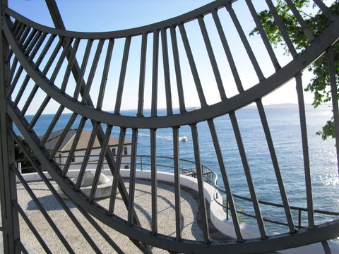 La mer à Bahia vue à travers les grilles d'un portail de fer.