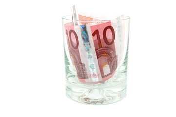Some euro banknotes in a tumbler isolated on white background