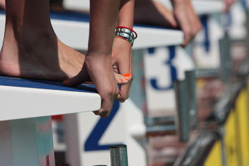 Female swimmer on blocks before dive