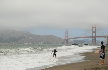 Two surfers against the Golden Gate Bridge
