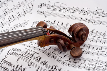 Old violin scroll on a sheet music