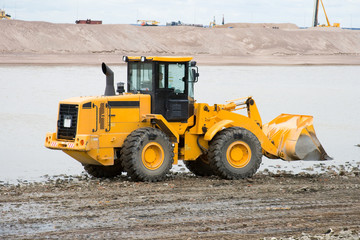 The bulldozer working in sandy career