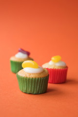 Selection of fairy cakes on orange - shallow dof