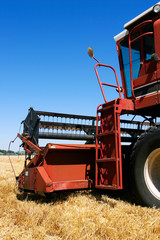 Fototapeta premium combine harvester closeup on field under blue sky