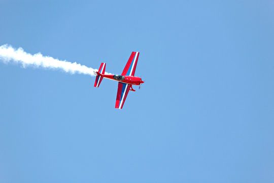 Aerial Acrobatics - Red Propeller Plane With Smoke Blue Sky