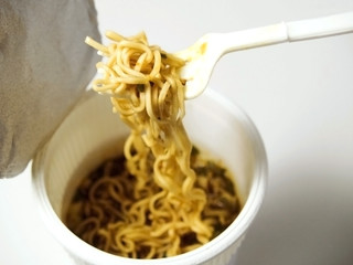 A cup of instant microwaveable noodle soup close up