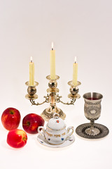 cup candlestick and apple dish on white background
