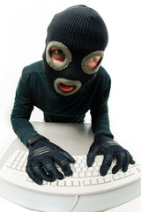 Criminal in balaclava pressing buttons of keyboard