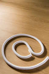Obraz premium Telephone Cord Making 'At' Symbol