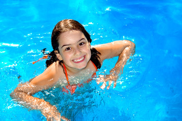 Happy young girl having fun in the swimming-pool