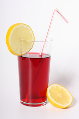 Glass of hibiscus tea with straw and two lemon slices