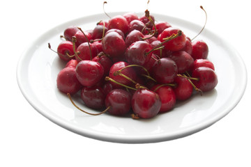 plate of sweet cherries islated on white