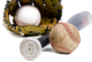 A well used football, baseball and bat. Isolated on white.