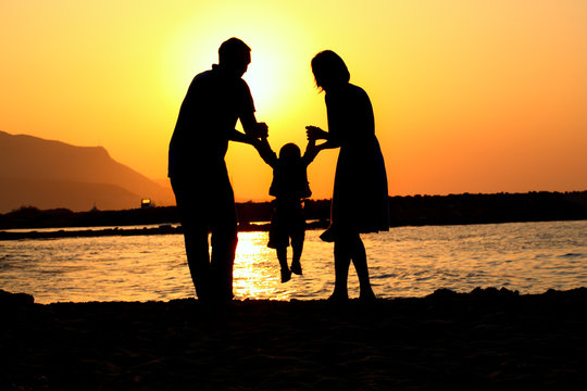 happy family of three playing silhouette