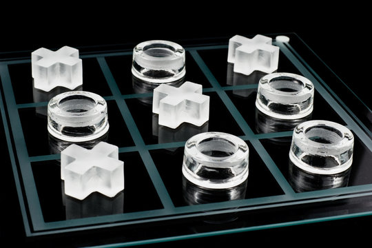 Glass tic-tac-toe game on black background