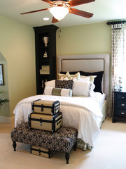 A nicely decorated bedroom with a collection of suitcases