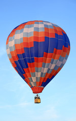 Fototapeta premium Vivid hot air balloon floating in the blue sky.