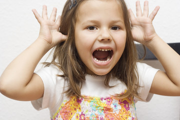 portrait of little girl making faces. isolated on white