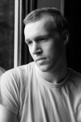 natural light portrait of man in t-shirt at a window