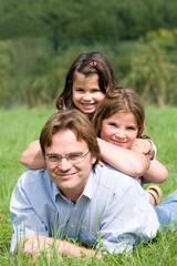 Young father with his two duaghters in a farmer´s field