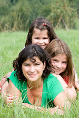 Fototapeta premium Young mother with her two daughters in a farmer´s field