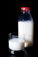 A glass of milk and a milk bottle.