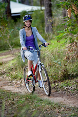 A young woman riding a bicycle in the woods