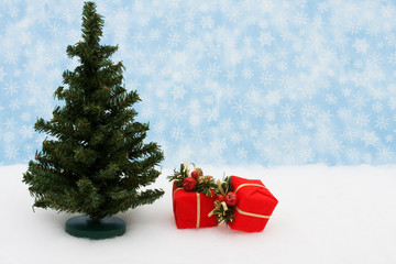 Tree with two red presents on snow with snowflake background