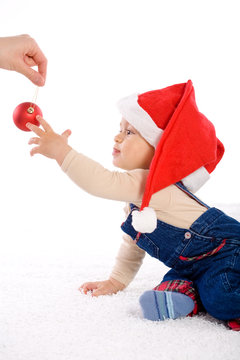 One year old baby boy in santa's hat, smiling.