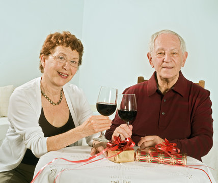 senior couple having wine and exchanging gifts
